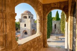 The Filerimos monastery bell tower framed through stone arches