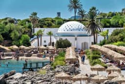 The white perforated dome of the Kallithea Springs Rotunda above the cove